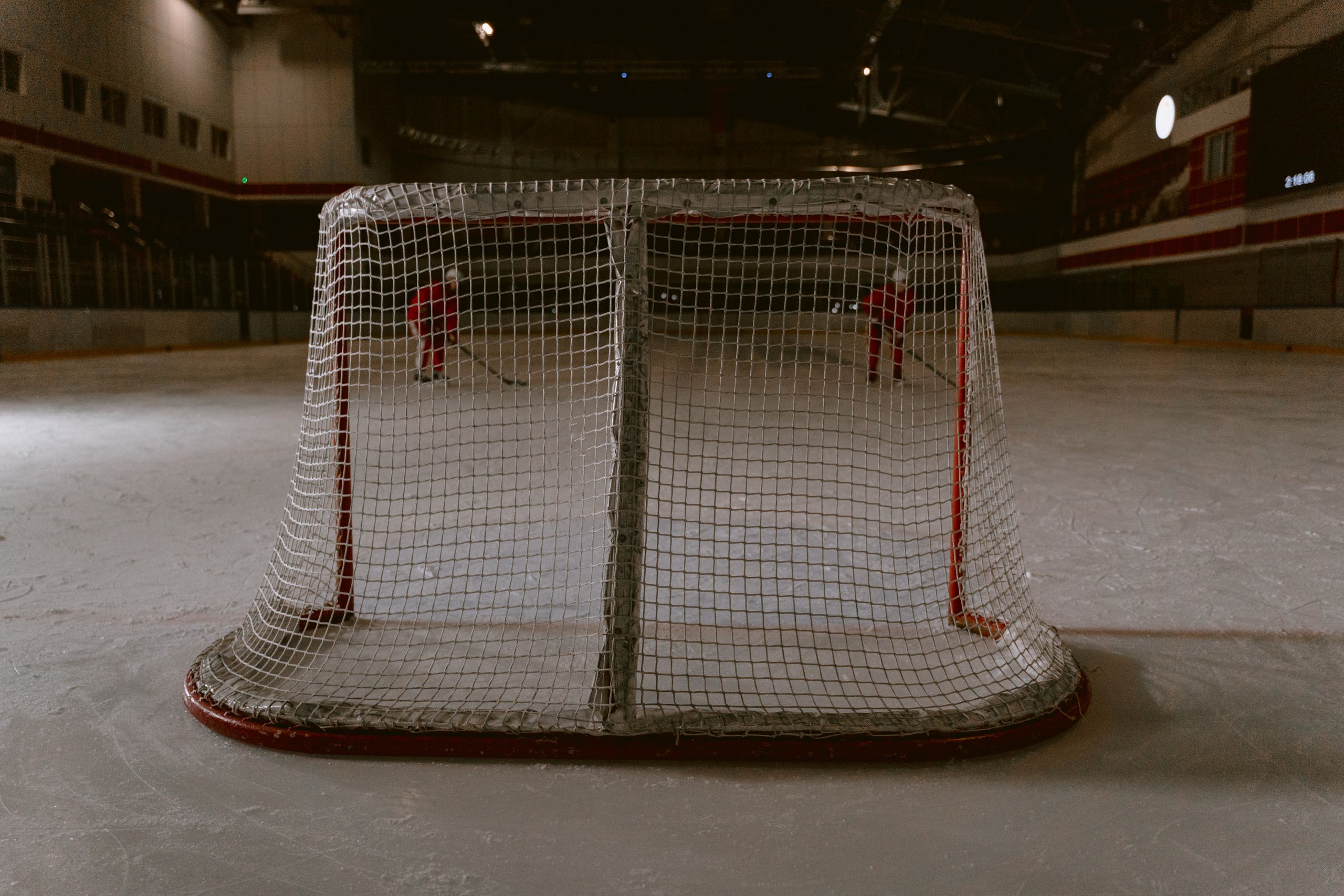 Intense hockey game in an indoor rink with focus on the goalpost.